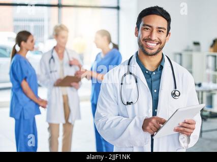Concentrate all your thoughts upon the work in hand. a young male doctor standing in a hospital. Stock Photo