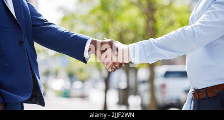 No ordinary deal. two unrecognizable businesspeople sharing a handshake outside. Stock Photo