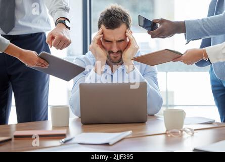 When do all the demands end. a young businessman feeling stressed out in a demanding office environment at work. Stock Photo