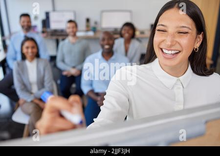 Voice or ideas, or write it. a young businesswoman writing notes while giving a presentation to her colleagues in an office. Stock Photo