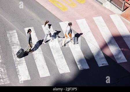 The corporate world is waiting for us. a group of young businesspeople crossing the road in the city. Stock Photo