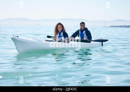 Laidback and enjoying themselves out on the lake. Portrait of a young couple kayaking together at a lake. Stock Photo