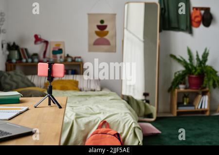 Horizontal image of smartphone on tripod standing on table preparing for online streaming in bedroom Stock Photo