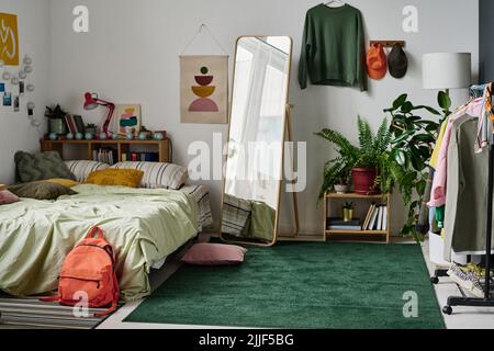 Stylish teenage room interior with comfortable bed and with clothing and mirror in the centre Stock Photo