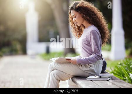 Expand your mind with some reading. a young female student studying in nature. Stock Photo