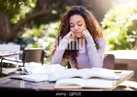 All this studying but wheres the motivation. a young female student studying at a cafe. Stock Photo