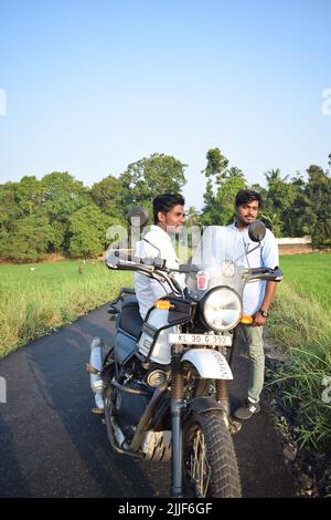 An Indian man sitting on a motorbike and posing for photo Stock Photo