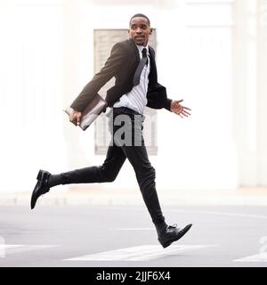 He cant afford to be late. Full length shot of a handsome young businessman rushing through the city on his way into work. Stock Photo