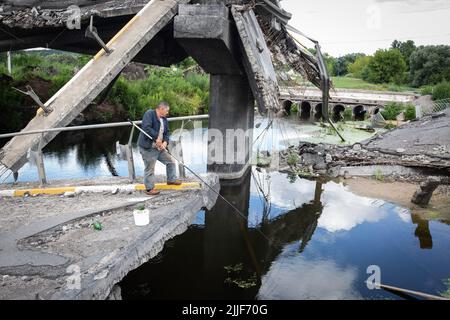 Irpin, Ukraine. 12th July, 2022. A man seen fishing on the bridge across the destroyed Irpin River by the Ukrainian army to stop the advance of Russian troops from advancing to Kyiv. Russia invaded Ukraine on February 24, 2022. (Credit Image: © Oleksii Chumachenko/SOPA Images via ZUMA Press Wire) Stock Photo