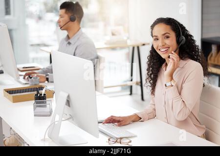 Staying organised for another busy day. Portrait of a young call centre agent working on a computer in an office. Stock Photo