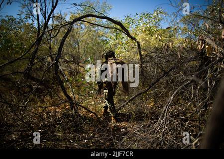 A U.S. Marine with 3d Battalion, 7th Marine Regiment, Ground Combat Element, Marine Rotational Force-Darwin 22, maneuvers through Royal Australian Air Force Base Curtin, WA, Australia during an airfield seizure event as part of exercise Koolendong 22, July 18, 2022. Exercise Koolendong 22 is a combined and joint force exercise focused on expeditionary advanced base operations conducted by U.S. Marines, U.S. Soldiers, U.S. Airmen, and Australian Defence Force personnel. (U.S. Marine Corps photo by Cpl. Cedar Barnes) Stock Photo