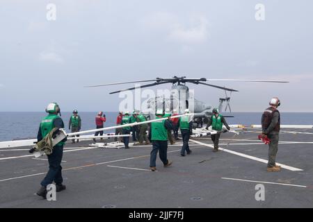 220725-N-XB010-1007 SOUTH CHINA SEA (July 25, 2022) Sailors assigned to the forward-deployed amphibious transport dock ship USS New Orleans’ (LPD 18) and Marines assigned to the 31st Marine Expeditionary Unit (MEU) approach a AH-1Z Cobra helicopter with a blade fold rack on New Orleans’ flight deck. New Orleans, part of the Tripoli Amphibious Ready Group, along with the 31st MEU, is operating in the U.S. 7th Fleet area of responsibility to enhance interoperability with allies and partners and serve as a ready response force to defend peace and stability in the Indo-Pacific region. (U.S. Navy p Stock Photo