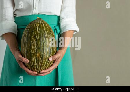 Woman chef holding a green melon - stock photo Stock Photo