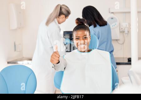 This is a great place to be. a young woman in her dentists office giving the thumbs up. Stock Photo