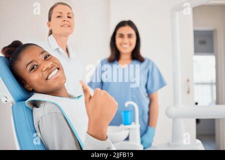 Time for an oral makeover. a young woman in her dentists office giving the thumbs up. Stock Photo