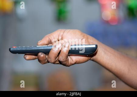 Hand holding Multimedia remote control Stock Photo