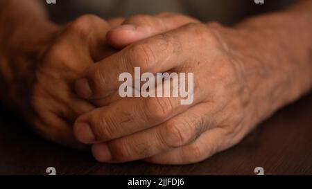 Hands of the older man on the table in close-up Stock Photo