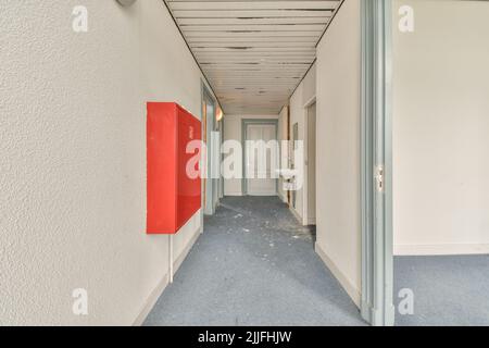 Interior of modern flat in minimal style with narrow empty corridor illuminated by lamps Stock Photo