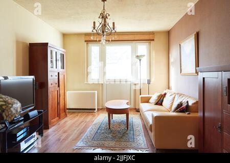Old-fashioned living room with kidney-shaped table and antique furniture and carpet in an apartment Stock Photo