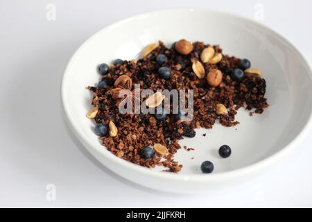 Homemade Granola with Nuts and Blueberries in White Bowl. Breakfast at Home. Stock Photo