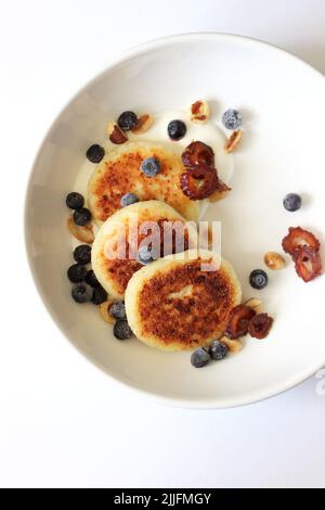 Breakfast Cottage Cheese Pancakes Served with Sour Cream, Blueberries, Nuts and Dates. Homemade Breakfast Concept. Stock Photo