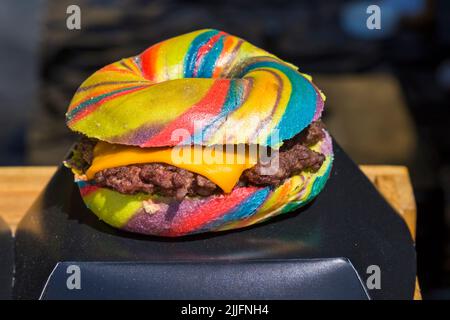 Unicorn Burger Hampshire minced steak rainbow bagel glitter for sale on food stall at event in Poole, Dorset UK in July Stock Photo