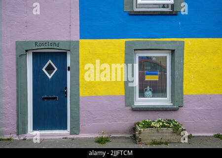 Colourfully painted house with the colours of the Ukraine flag, Borth, Ceredigion, Wales Stock Photo