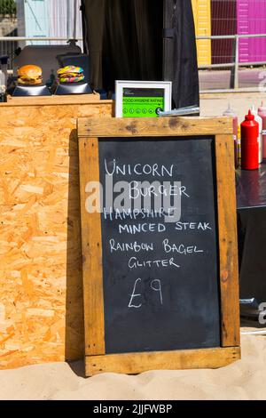 Unicorn Burger Hampshire minced steak rainbow bagel glitter for sale £9 on food stall at event in Poole, Dorset UK in July Stock Photo