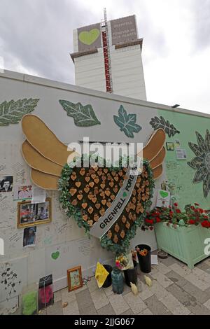 Grenfell Tower fire tragedy block, shown behind the memorial wall for the 72 victims. Grenfell United, Forever, after the cladding fire in 2017 Stock Photo