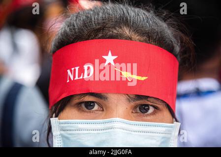 Bangkok, Thailand. 26th July, 2022. A protester looks on while wearing a National League for Democracy (NLD) headband during the demonstration. Protesters gathered outside the Burmese embassy in Bangkok, Thailand to protest against the Burmese military after the Burmese Military's government executes 4 democracy activists including Kyaw Min Yu better known as Ko Jimmy and Myanmar rap pioneer Phyo Zeya Thaw. Credit: SOPA Images Limited/Alamy Live News Stock Photo