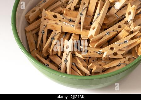 Den Helder, Netherlands. July 2022. An enamel bowl with wooden clothes pegs on a white background. High quality photo. Isolated. Stock Photo