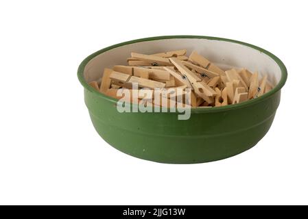 Den Helder, Netherlands. July 2022. An enamel bowl with wooden clothes pegs on a white background. High quality photo. Isolated. Stock Photo