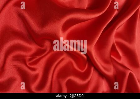 Red crepe satin crumpled or wavy fabric texture background. Abstract linen cloth soft waves. Silk fabric. Smooth elegant luxury cloth texture. Concept Stock Photo