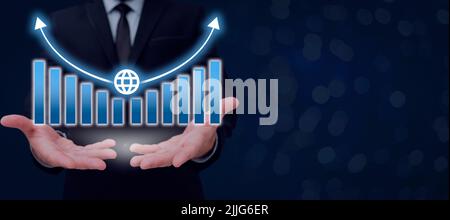 Businessman Holding Growth Graph Over Hands And Showing Crutial Announcements. Man In Suit Having Chart Above Palms And Presenting Important Stock Photo