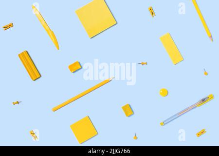 Flat lay with stickers, pens, pencils, plasticine, clothespins, paper clips in yellow and blue colors. Stock Photo