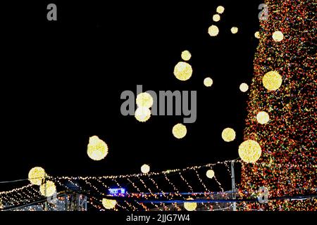 Beautiful Christmas tree and New Year's tree decorated multi-colored flashing garlands and lights at night. Christmas tree with flashing lights. New Year and Christmas holidays Stock Photo