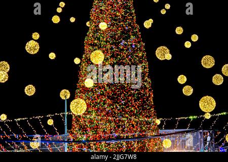 Beautiful Christmas tree and New Year's tree decorated multi-colored flashing garlands and lights at night. Christmas tree with flashing lights. New Year and Christmas holidays Stock Photo