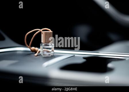 Car air perfume freshener bottle inside the car on car panel. Aromatic liquid in the small bottle Stock Photo