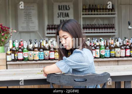 Beautful young women sitting in art nightclub bar with alcohol bottle