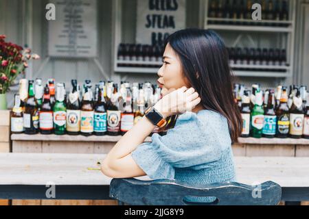 Beautful young women sitting in art nightclub bar with alcohol bottle