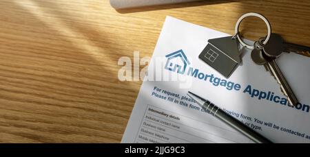 mortgage loan application form and new home keys on the bank office table. copy space Stock Photo