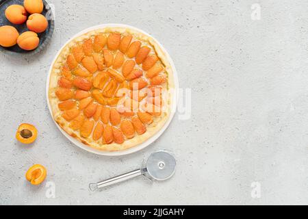 Fruit pizza with peaches and peaches on a gray background, homemade summer pie, top view with copy space Stock Photo