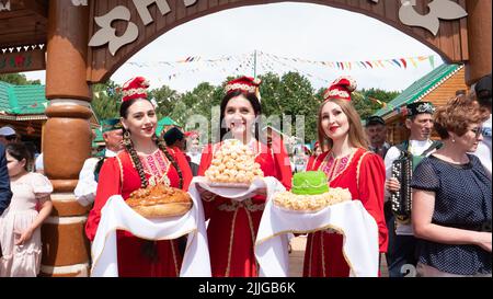 Kazan, Russia. 2022, June 18. Meeting guests according to Tatar customs. Girls in national costumes offer to taste the chak-chak. Traditions of Tatar hospitality Stock Photo