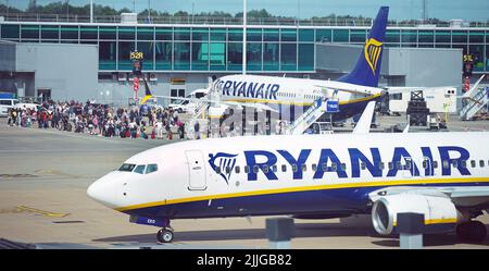 A stock picture of passengers queuing up to get on Ryanair planes at Stansted Airport. Picture date: Tuesday July 26, 2022. Stock Photo