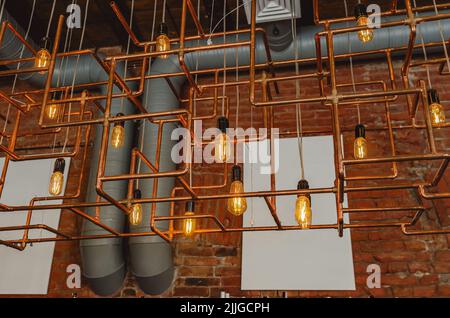 Modern loft lamp made of copper pipes in cafe Stock Photo