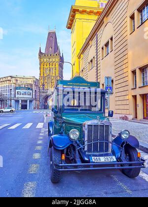 PRAGUE, CAZECH REPUBLIC - MARCH 6, 2022: The vintage car for tourist guided tours is parked on Hybernska Street with Powder Tower in background, on Ma Stock Photo