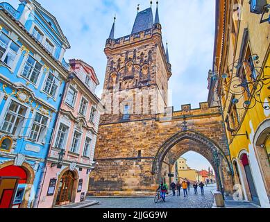 PRAGUE, CAZECH REPUBLIC - MARCH 6, 2022: The Mostecka Street with colored historic townhouses opens the view on Mala Strana Bridge Tower of Charles Br Stock Photo