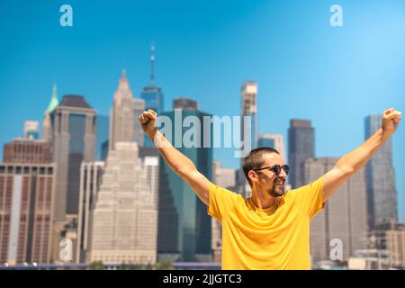 Young attractive man with raised arms happy smiling win celebration in the city skyline. Stock Photo