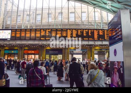 London, UK. 26th July 2022. Passengers wait for train information at King's Cross station on the day before the national rail strike as disputes over pay and working conditions continue. Damage to overhead electric wires caused major disruption to the train service to and from the station. Credit: Vuk Valcic/Alamy Live News Stock Photo