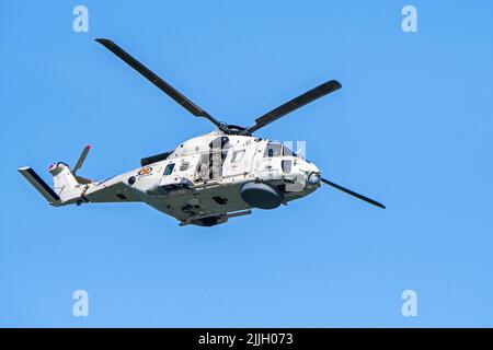 NATO-type NFH / Naval Frigate Helicopter NH-90 of the Belgian Army Air Component in flight against blue sky at Koksijde / Coxyde, Belgium Stock Photo